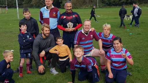 The inclusive rugby team, a group of children and adults on a rugby field.